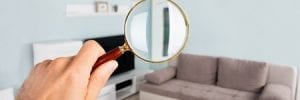 Person Inspecting Home with Magnifying Glass